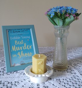 arrangement of book cover, candle and vase