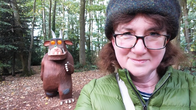selfie of Debbie with Gruffalo coming up behind her in the woods