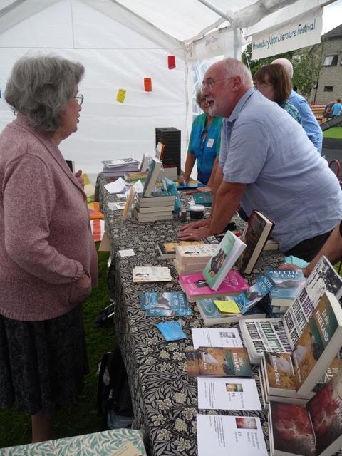 Photo of reader talking to author in show tent
